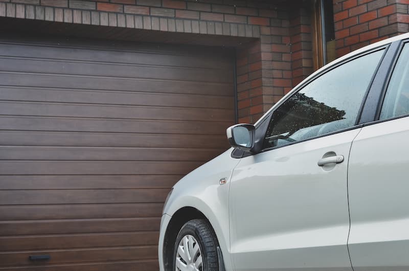 White car approaching wood effect garage door